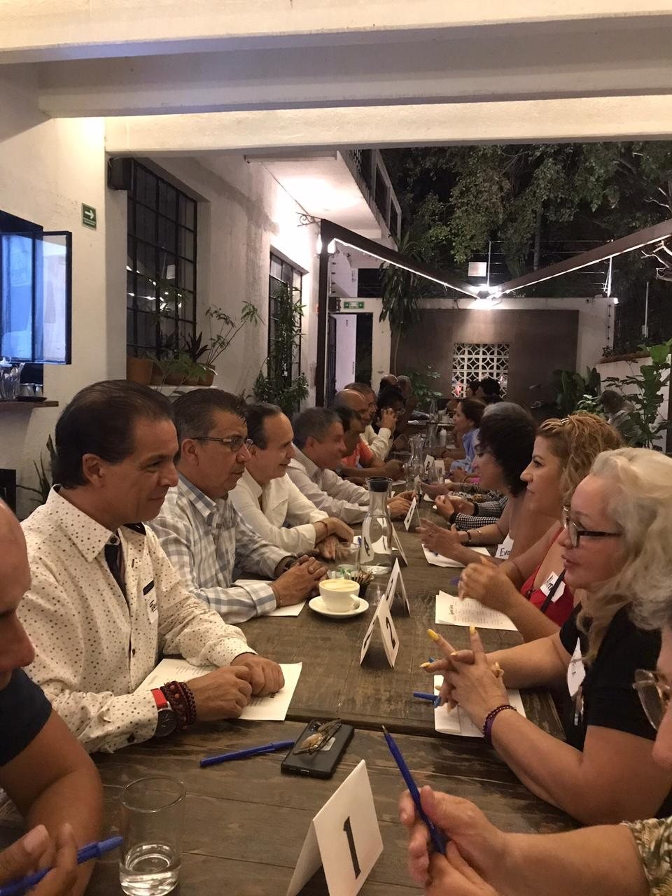 Asistentes conversando en una mesa larga